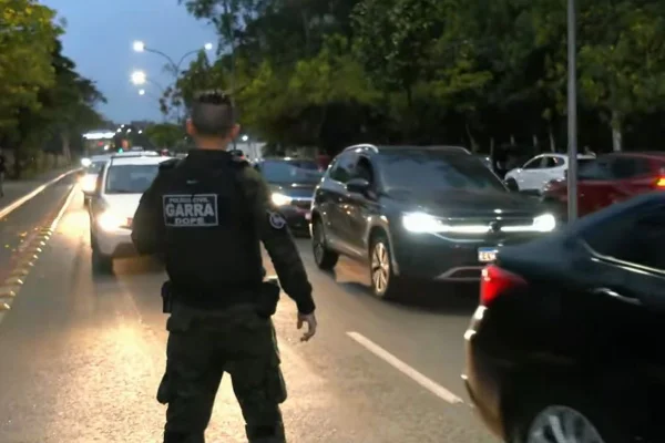 Imagem colorida mostra policial civil durante operação contra falsos entregadores