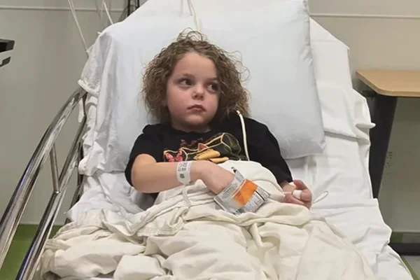 Foto colorida de criança em ambiente hospitalar, deitado numa maca e conectados a tubos - Metrópoles.