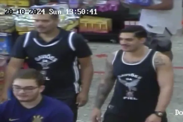Print de vídeo de câmera de segurança que mostra três rapazes. Dois estão com uma camiseta preta da Gaviões da Fiel, e um com uma camiseta roxa do Corinthians