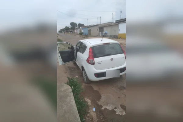 foto colorida de carro branco parado em rua com porta aberta