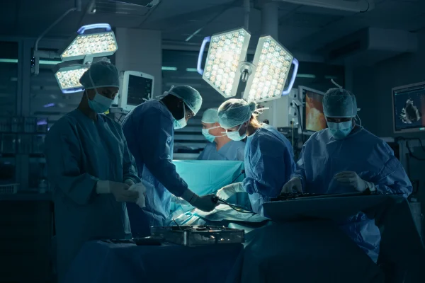 Imagem mostra vários médicos fazendo uma cirurgia em um paciente - Metrópoles