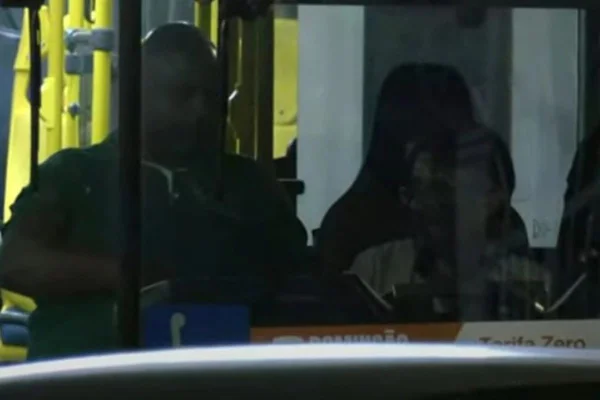 Imagens coloridas mostram um homem negro, vestindo uma camiseta verde, dentro de um ônibus, ao lado de outro homem, de camisa branca