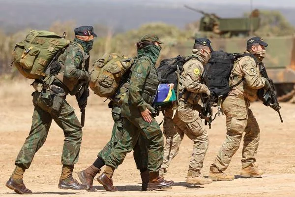 Fotografia colorida de quatro militares fardados