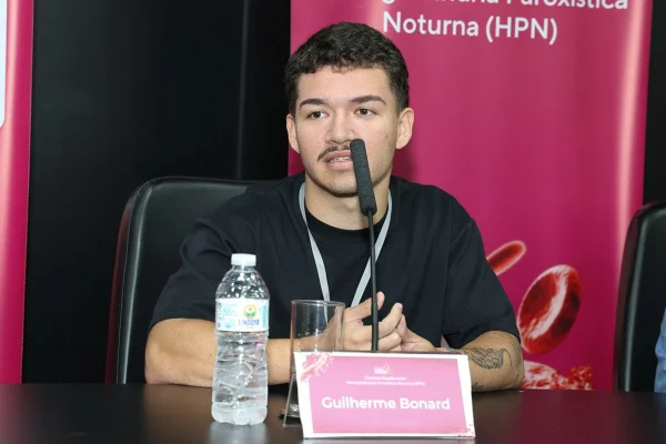 Foto mostra o jovem Guilherme durante um evento sobre a doença HPN. Metrópoles