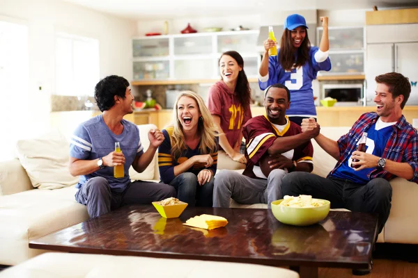 Foto de grupo de pessoas assistindo um jogo na televisão