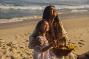 Preta Gil e a neta, Sol de Maria,  posam juntas e sorridentes na praia