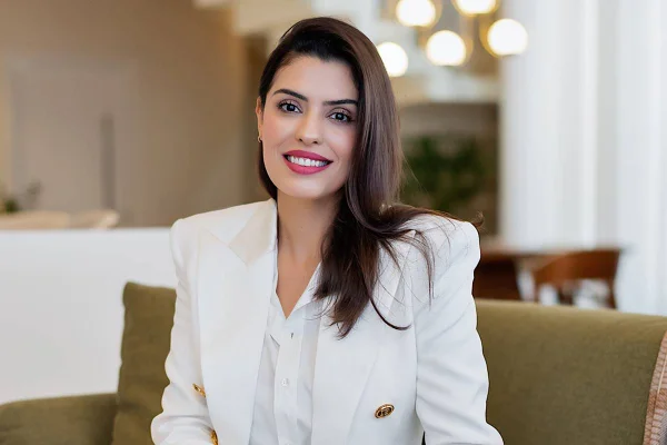 Mulher sentada no sofá com terno branco