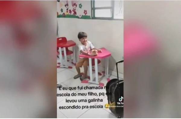 imagem colorida menino leva galinha para escola escondida na mochila