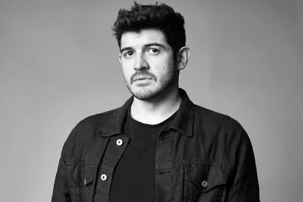 Imagem em preto e branco do dublador Alexis Ortega - Metrópoles