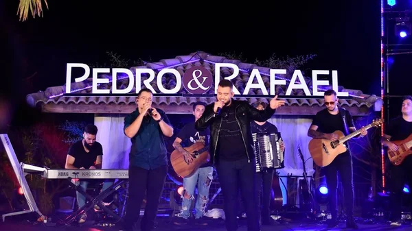 Foto colorida de Pedro e Rafael cantando no palco - Metrópoles