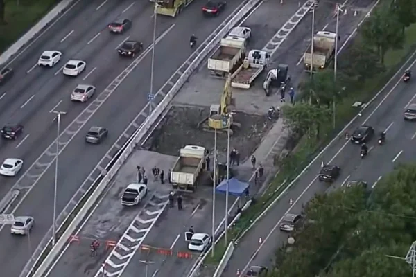 Imagem colorida de cratera na Marginal Tietê sendo reparada na Marginal Titê