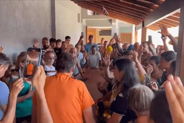imagem colorida mostra jair bolsonaro cercado por apoiadores que oram por ele - Metrópoles