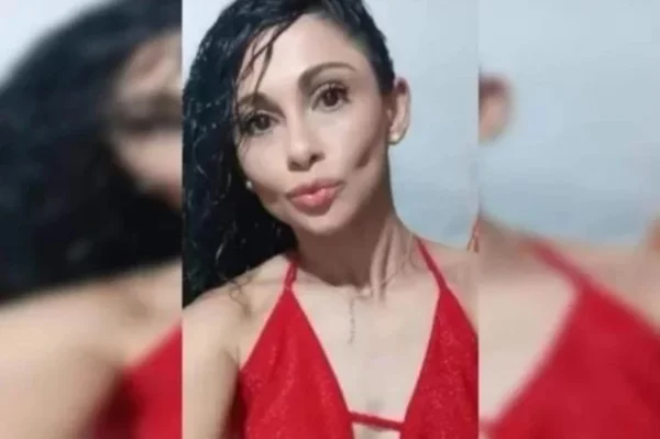 Foto colorida de mulher com a pele clara usando cabelos pretos e vestido vermelho