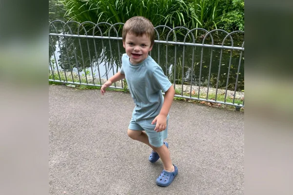Foto de menino de azul correndo em parque - Metrópoles
