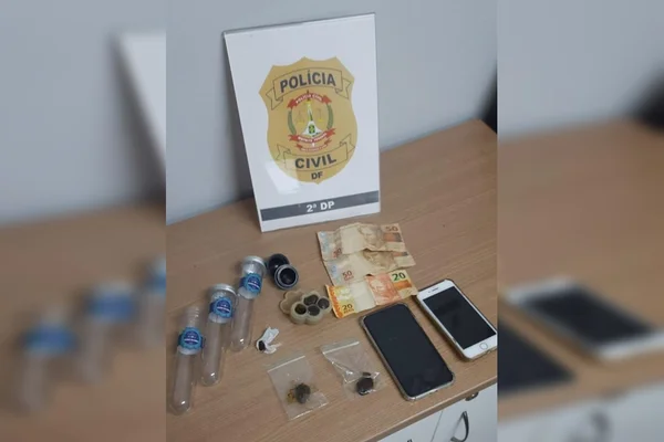 Objetos encontrados pela Polícia Civil do Distrito Federal espalhados em mesa, dentre haxixe paquistanês, notas de dinheiro, celulares e outros - Metrópoles