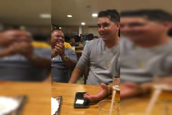 Imagem de dois homens e uma mesa cantando parabéns