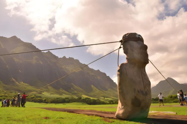 Imagem colorida mostra pessoas puxando estátua através de cordas na Ilha de Páscoa - Metrópoles
