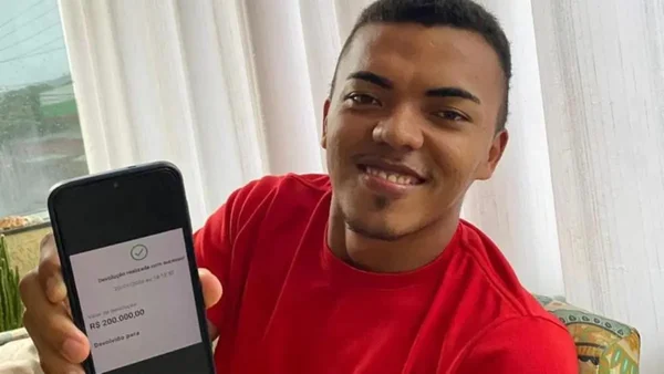 homem sorrindo segurando celular