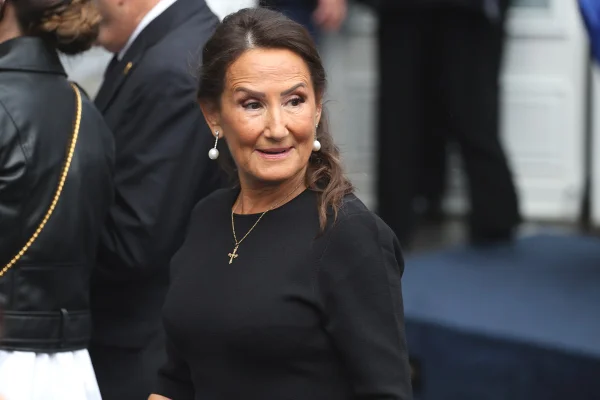 Foto colorida de mulher com roupa preta, cabelo preso e colar com crucifixo - Metrópoles