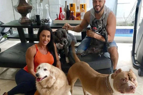 Foto colorida de um casal com um cachorro - Metrópoles