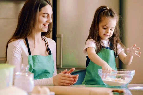 Criança cozinhando com a mãe