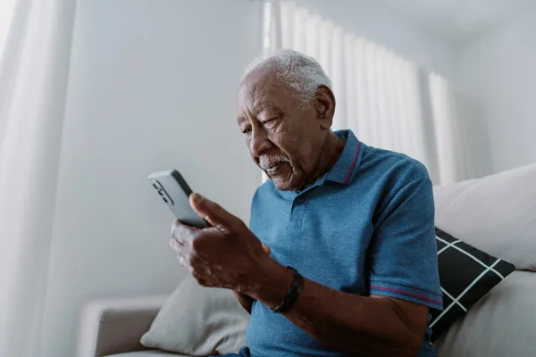Idoso fala em telefone celular com expressão grave - Metrópoles - Alzheimer fala