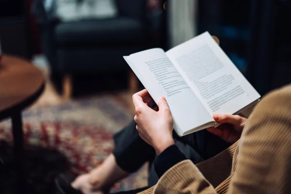Foto colorida de mulher lendo livro. Ler ou ouvir, cérebro, absorção
