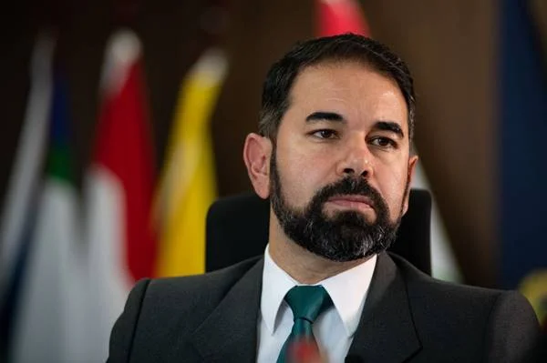 Imagem colorida de homem de terno com bandeiras ao fundo