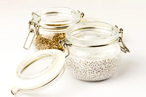 Pudim de chia leite com sementes de chia e sementes secas em potes de vidro. Close. Foco seletivo