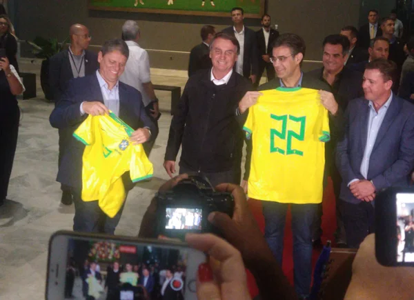 Bolsonaro posa ao lado de Tarcísio de Freitas e de Rodrigo Garcia, que seguram camisas da Seleção Brasileira