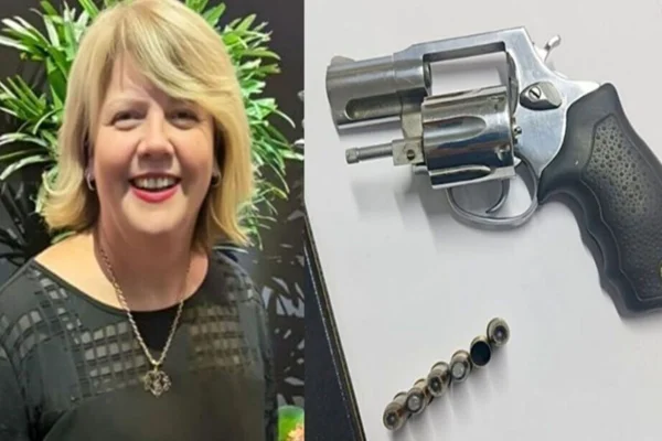 Mulher ao lado de uma arma