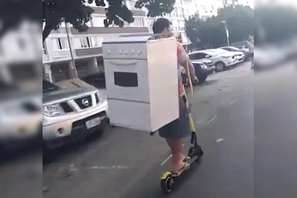 Homem é filmado transportando fogão nas costas em patinete elétrico