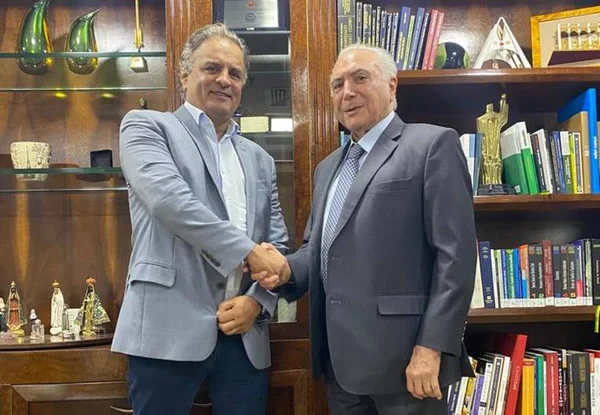 O deputado federal Aécio Neves cumprimenta o ex-presidente Michel Temer num escritório cheio de livros nas prateleiras - Metrópoles