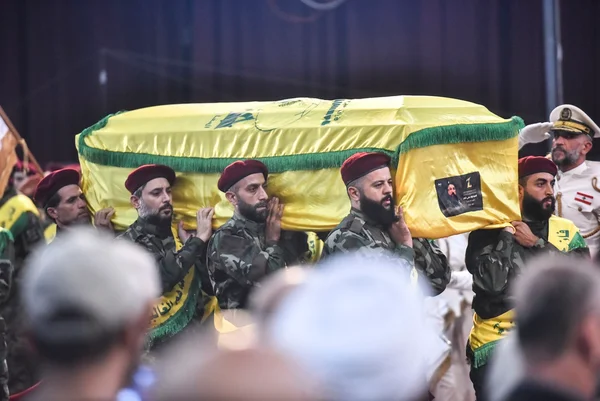 Combatentes do Hezbollah carregam o caixão de Fuad Shukur