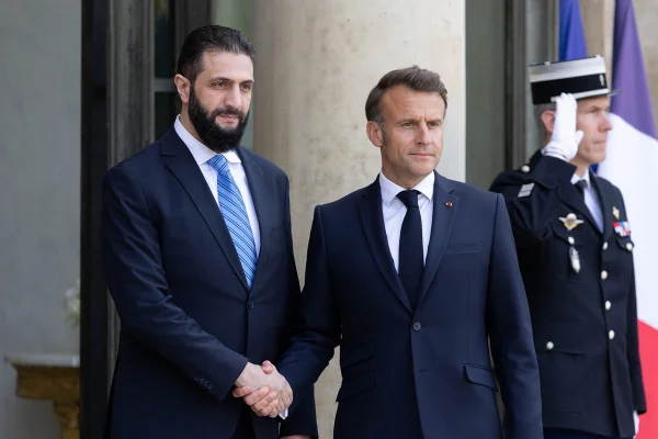 Imagem colorida, o presidente francês, Emmanuel Macron, aperta a mão do presidente sírio, Ahmed al-Sharaa- Metrópoles