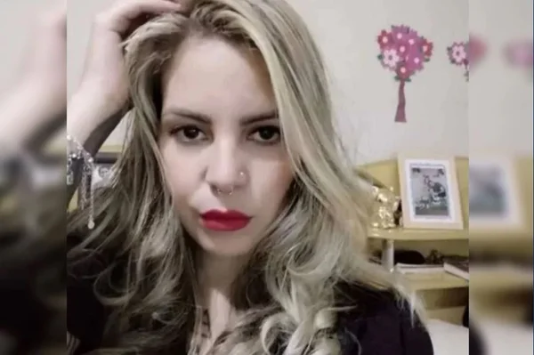 Imagem colorida de mulher branca loira com a mão no cabelo
