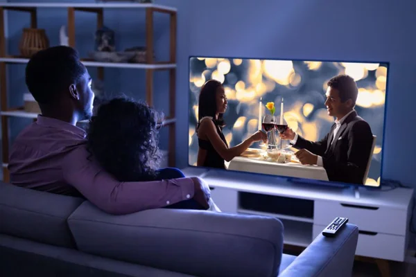 sala de TV com um casal assistindo - Metrópoles