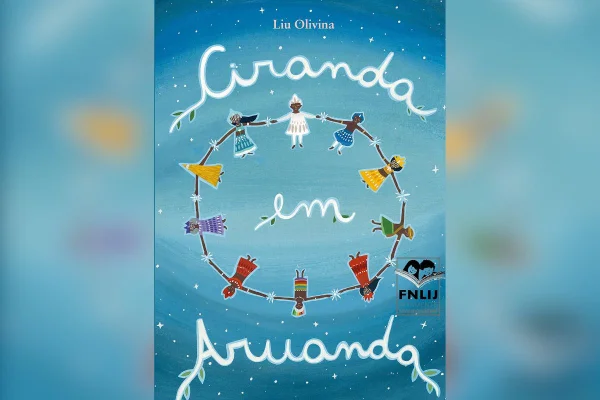 imagem colorida mostra capa de livro infantil "ciranda em aruanda". capa tem o nome escrito com letra cursiva e cor branca. fundo é azul e personagens fazem uma roda no centro da capa