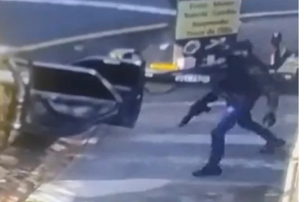 Homem com fuzil se dirige em direção a carro com portas abertas - Metrópoles