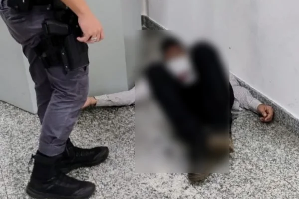 Imagem colorida de homem caído no chão após ser baleado em um banco. Metrópoles
