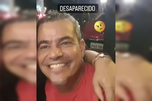 Homem com camisa vermelha sorrindo com uma mão no ombro dele