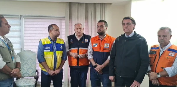 Bolsonaro com o governador do Rio de Janeiro Cláudio Castro, autoridades locais e ministros. Eles estão um ao lado do outro, com coletes especiais - Metrópoles