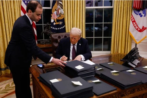 Foto colorida de Donald Trump assinando ordem - Metrópoles