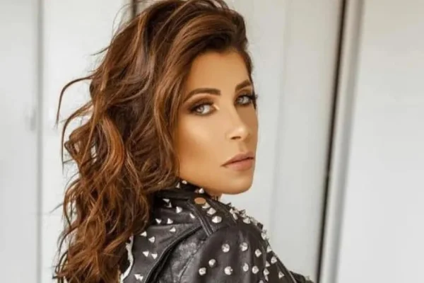 Imagem colorida de Aline Maschietto, uma mulher branca, de cabelos longos castanhos, olhos claros, de lado, mas olhando para a câmera, que foi extraditada ao Brasil; ela estava foragida na Espanha - Metrópoles