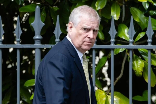 Foto de um homem olhando para frente, com uma grade ao fundo. O homem é o ex-príncipe Adrew, envolvido no caso Epstein