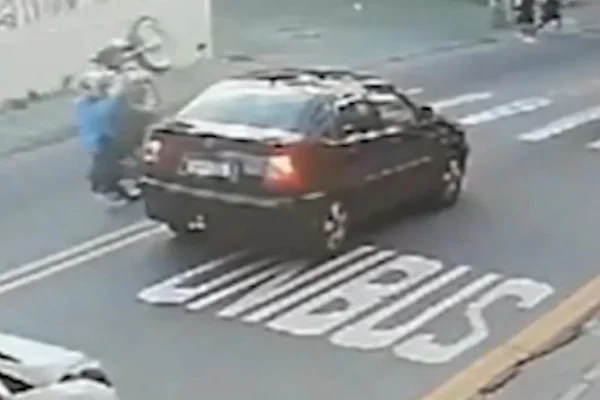 Imagem colorida de adolescente empinando moto antes de atropelar idosas. Metrópoles