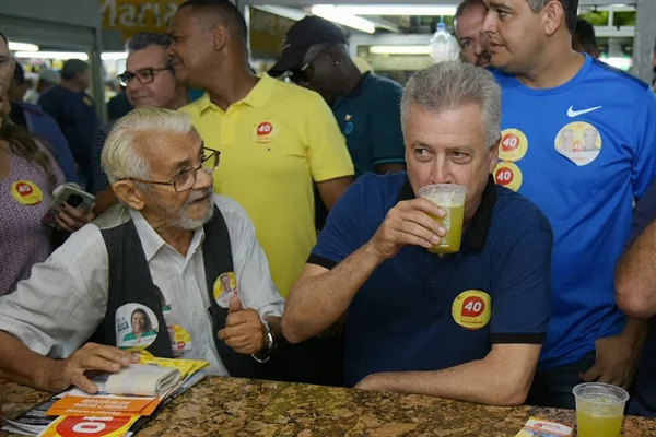 À caça de votos, Rollemberg toma caldo de cana e come pastel em feira
