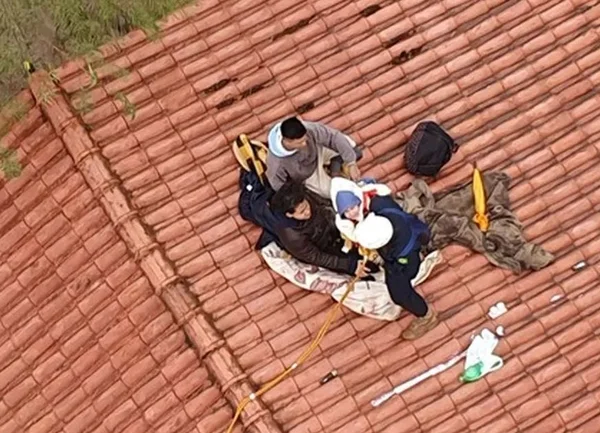 Imagem colorida mostra bebê em telhado durante enchente