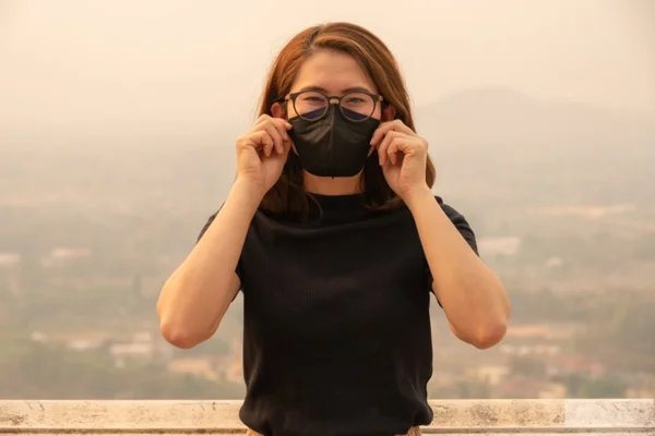 Mulher de óvulos usa máscara para se proteger de fumaça - Metrópoles