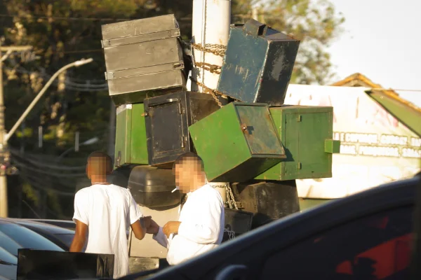 Dois homens de camiseta branca conversando em frente aos armários citados na matéria